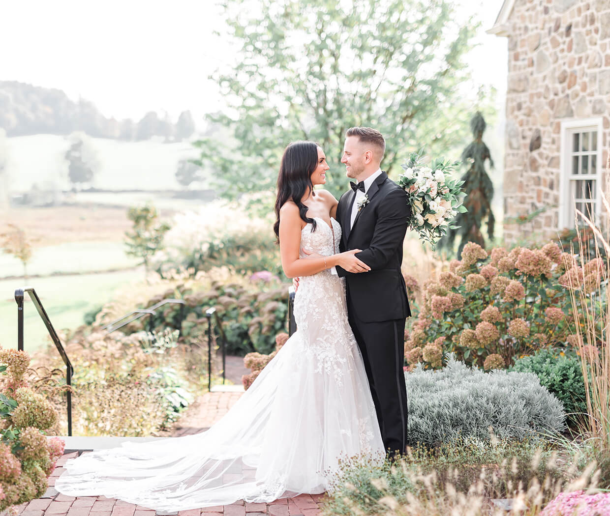 bride and groom by stone building