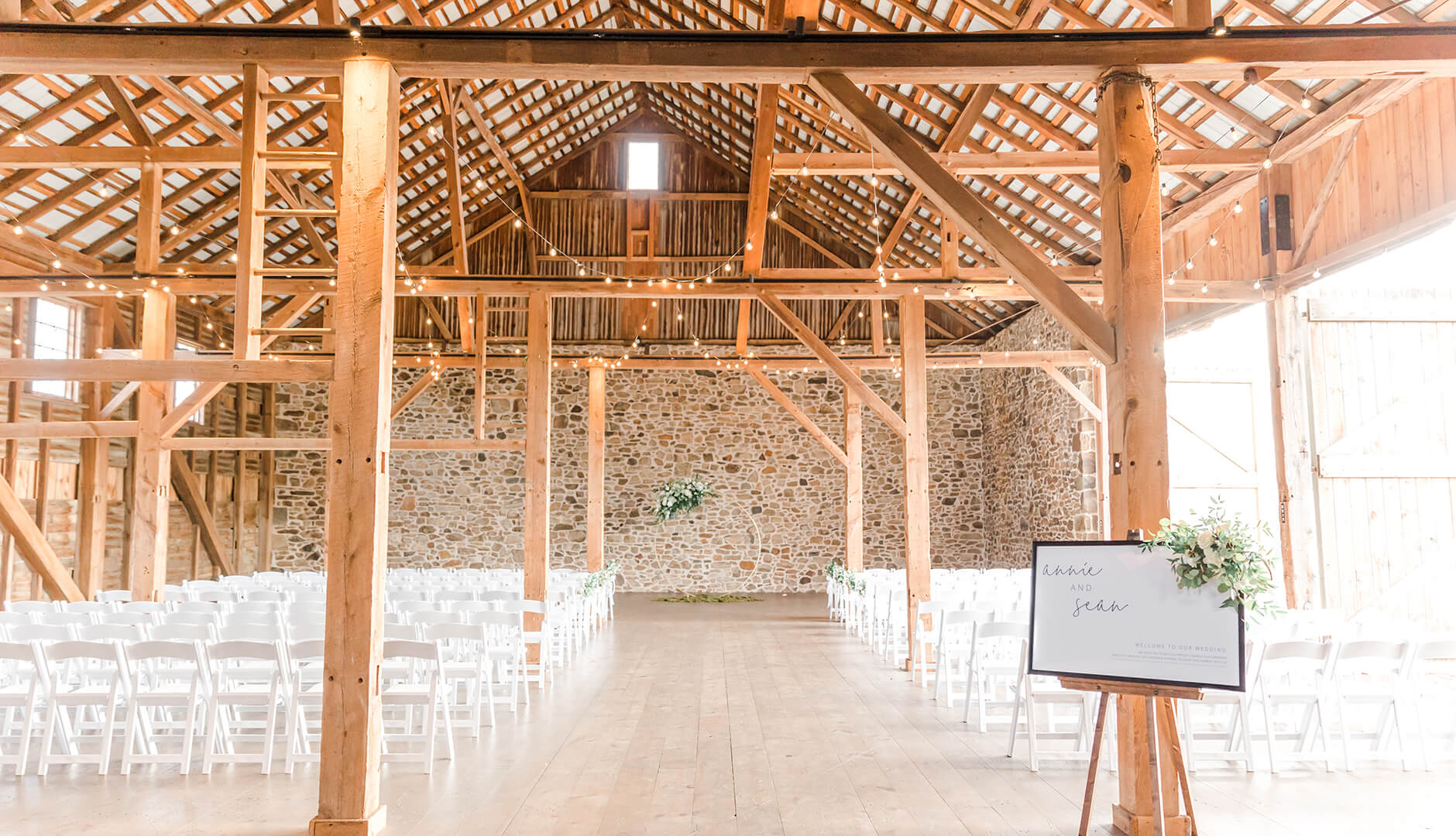 barn style wedding venue with white chairs